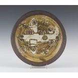 A Bryan Newman, Aller studio pottery charger, decorated in oxides with a bomber aircraft,