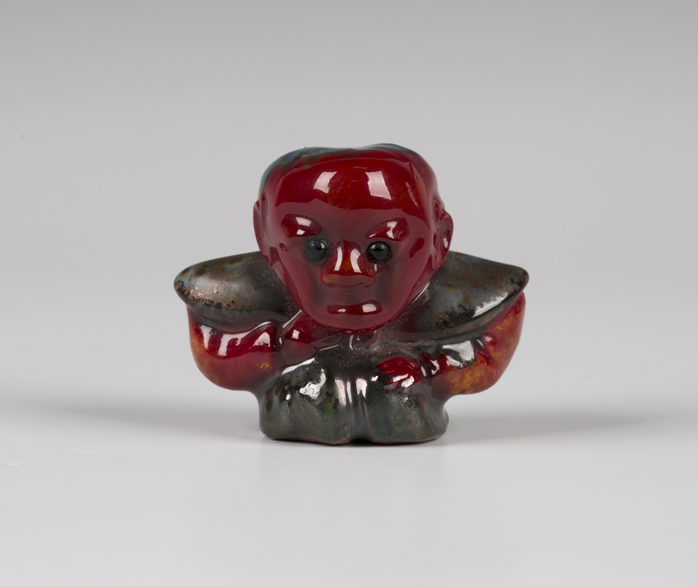 A Bernard Moore red flambé glazed figure of Diakokan, early 20th century, modelled as a squat