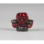 A Bernard Moore red flambé glazed figure of Diakokan, early 20th century, modelled as a squat