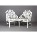 A pair of 20th century white painted cast iron garden armchairs, after a design by Edward Bawden,