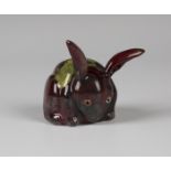 A Bernard Moore red flambé glazed model of a rabbit, early 20th century, with yellow mottled