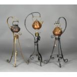 A group of three Arts and Crafts copper and brass mounted kettles by Benham & Froud, the designs