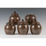 A set of five Michael Cardew, Wenford Bridge studio pottery storage jars with four covers, the