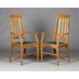 A pair of Edwardian Arts and Crafts Glasgow School oak elbow chairs, possibly designed by E.A.