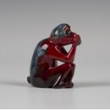 A Bernard Moore red flambé glazed model of a seated monkey, early 20th century, modelled holding a