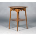 An Edwardian Arts and Crafts oak two-tier occasional table, probably by Liberty & Co, the square top