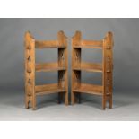 A pair of Edwardian Arts and Crafts oak three-tier 'Sedley' bookcases by Liberty & Co, the pegged