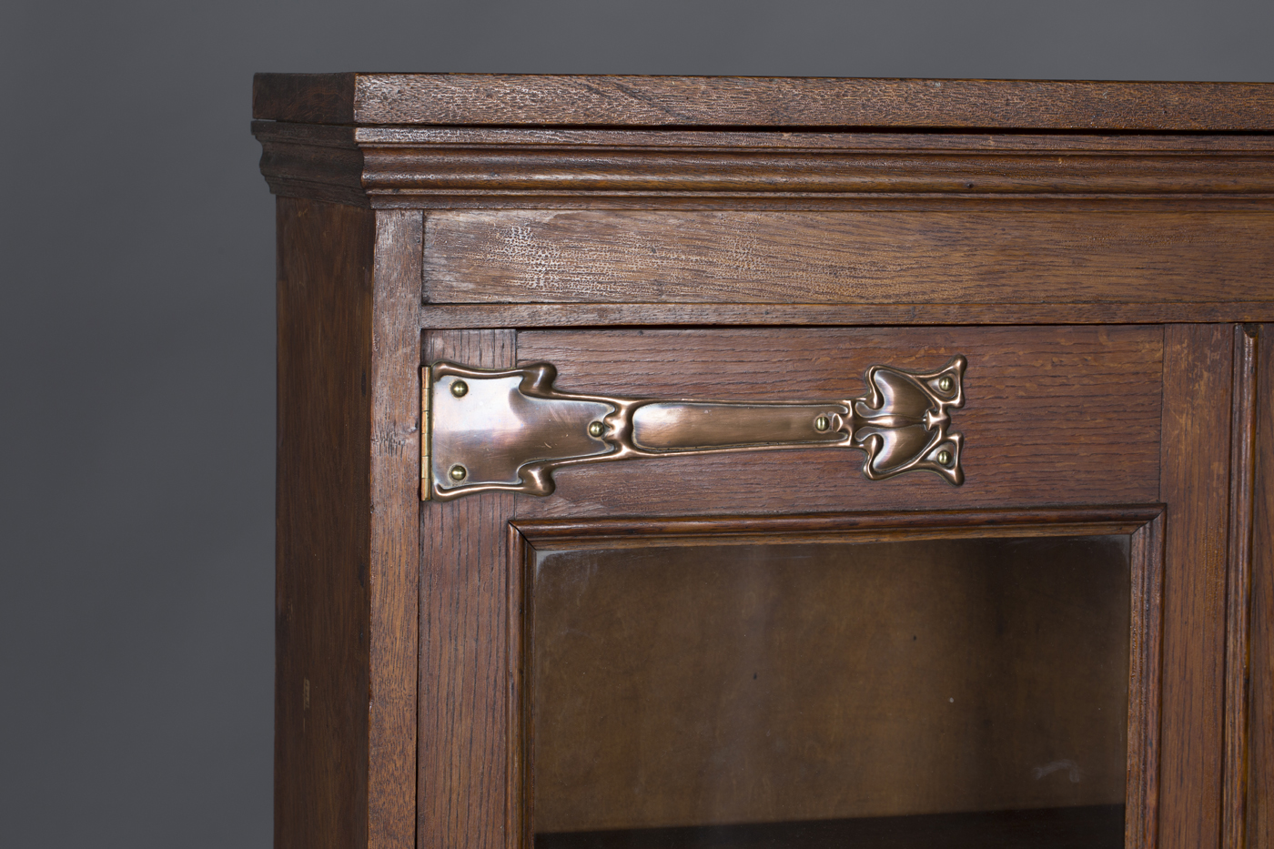 An Edwardian Arts and Crafts oak bookcase top, the two glazed doors with applied copper strapwork - Image 2 of 2