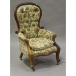 A Victorian mahogany gentleman's showframe armchair, upholstered in floral fabric, raised on