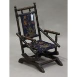 A late Victorian turned walnut child's rocking chair, raised on bracket feet, height 68cm, width