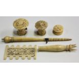 A group of 19th century carved ivory needlework implements, including two tape measures and a thread