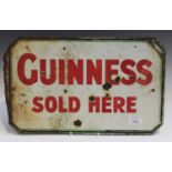 A double-sided 'Guinness Sold Here' enamelled advertising sign, marked 'Produced in Great Britain by