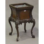 An early 20th century mahogany grotto style jardinière, the square body inset with a metal liner,