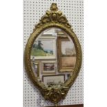 A late Victorian gilt painted composition oval girandole wall mirror with a foliate scroll and