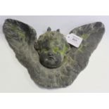 An early 20th century lead garden wall plaque of winged cherub mask form, width 34cm.Buyer’s Premium