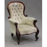 A Victorian mahogany carved showframe armchair, upholstered in cream velour, on cabriole legs,