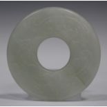 A Chinese jade bi (disc), probably 20th century, one side carved in low relief with a dragon and