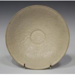 A Chinese Dingyao type porcelain circular bowl, Song style, the interior carved in low relief with