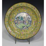 A Chinese Canton famille rose yellow ground enamel circular dish, late Qing dynasty, painted with