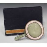 A Chinese copper, jade and enamelled hand mirror, late Qing dynasty, the mirror back inset with a