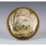 A Japanese Satsuma earthenware circular dish by Kinkozan, Meiji period, finely painted with a pair