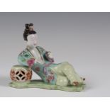 A rare Chinese famille rose enamelled porcelain figure of a recumbent lady, Qianlong period,