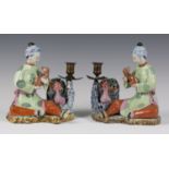 A pair of Chinese famille rose enamelled export porcelain figure groups of seated maidens with