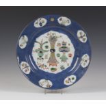 A Chinese famille verte powder blue ground porcelain circular dish, Kangxi period, painted with a