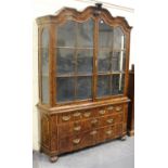 A 19th century Dutch burr walnut display cabinet, the arch moulded pediment above two glazed doors