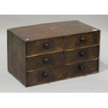 A 19th century pine and walnut table-top chest of six drawers with crossbanded borders and turned