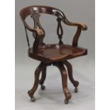 A mid-Victorian mahogany revolving tub back desk armchair, the pierced splat back above a solid