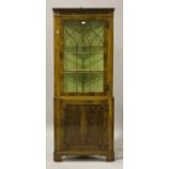 A late 20th century reproduction yew corner display cabinet, the astragal glazed door above a single