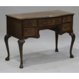 A late 20th century reproduction mahogany serpentine fronted dressing table, fitted with five