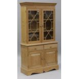 A modern pine kitchen cabinet, fitted with a pair of astragal glazed doors, the base with two