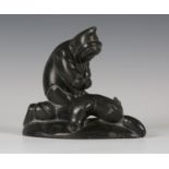 A Canadian carved dark green soapstone figure of an Inuit holding a seal, the base incised 'hal E9.