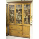 A 20th century walnut bookcase, fitted with three glazed doors above two drawers and a cupboard,