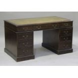 A 20th century reproduction mahogany twin pedestal desk, fitted with an arrangement of drawers and