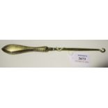 An early 20th century 9ct gold handled button hook, London 1930, length 24.5cm.Buyer’s Premium 29.4%