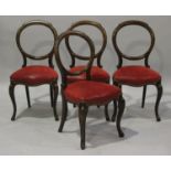 A set of four Victorian mahogany balloon back dining chairs with overstuffed seats, on cabriole