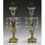 A pair of early 19th century cast ormolu and cut glass table lustre candlesticks, each flowerhead