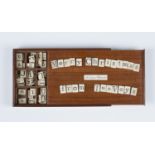 A 19th century mahogany cased bone alphabet set, the sliding lid inset with a plaque inscribed '