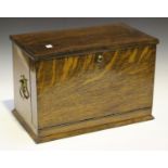 An Edwardian oak stationery box, the hinged lid and fall front enclosing a fitted interior with