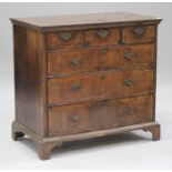 A George I walnut chest of three short and three long drawers with overall feather and crossbanded