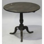 A late 18th century oak tip-top circular wine table, on a turned column and tripod cabriole legs,