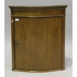 An Edwardian satinwood hanging corner cabinet, the serpentine front fitted with a single door,