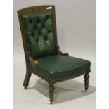 A late Victorian oak framed salon chair, upholstered in buttoned green leatherette, on turned legs