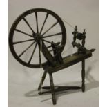 A 19th century stained pine spinning wheel with turned and block supports, height 100cm.Buyer’s