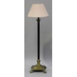 An early 20th century brass Corinthian column lamp standard with a black reeded stem and claw