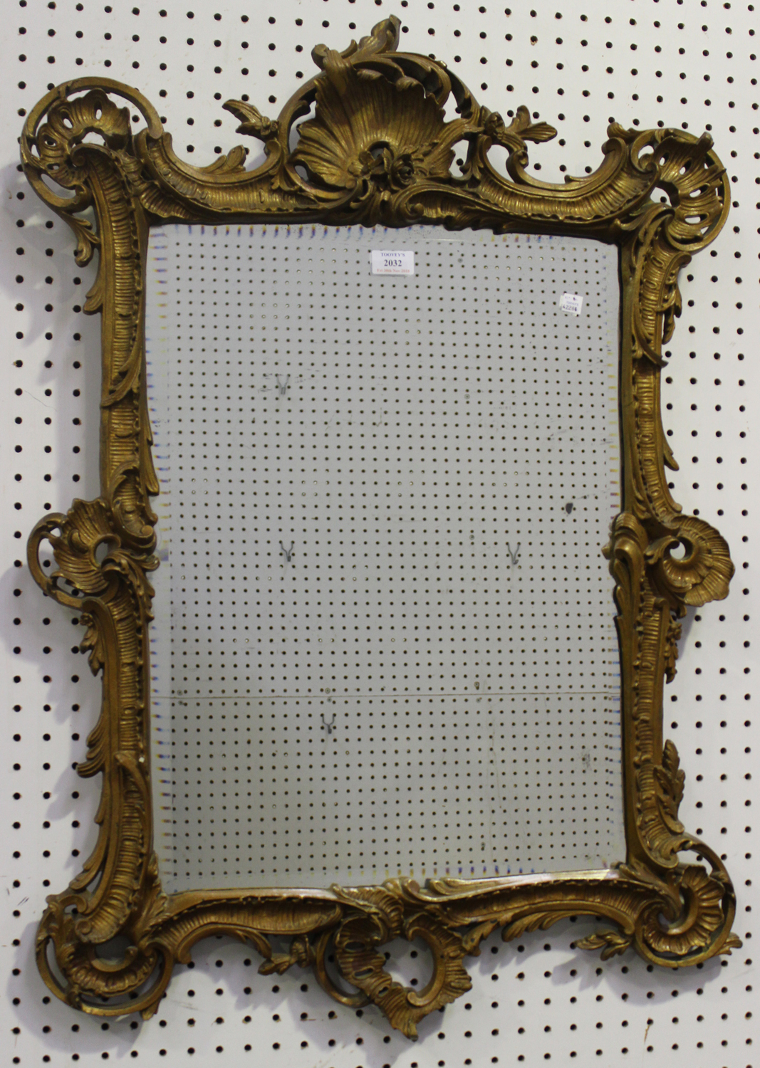 A late 19th/early 20th century Rococo Revival gilt painted composition wall mirror with a bevelled