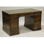 A 20th century mahogany twin pedestal desk, the moulded top inset with gilt-tooled green leather